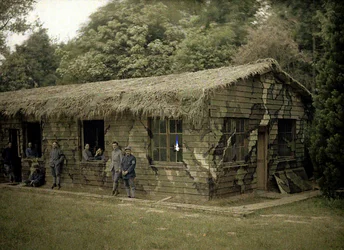Neun französische Soldaten an einem Holzgebäude mit militärischer Tarnung, Soissons, Aisne, Frankreich, 1917